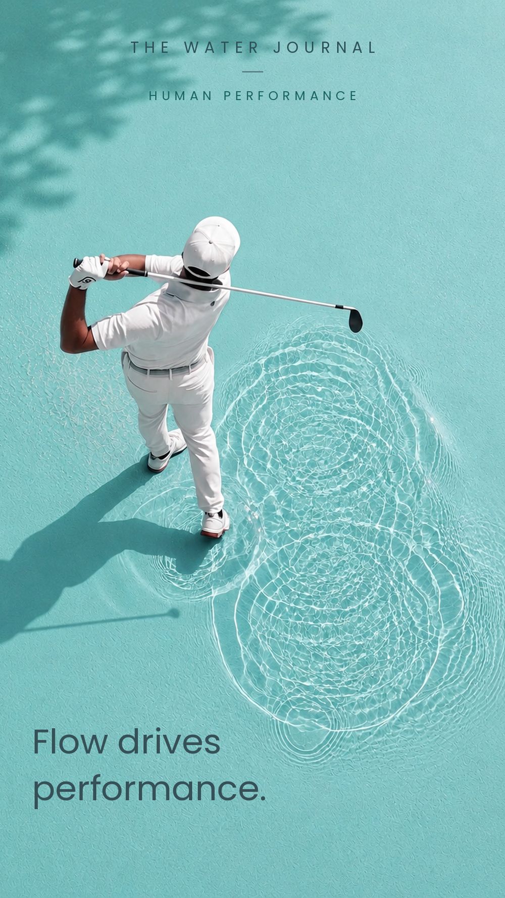 A golfer at the top of the follow-through, standing in shallow turquoise water